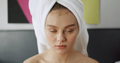 A Woman Applying Facial Cream On Her Face