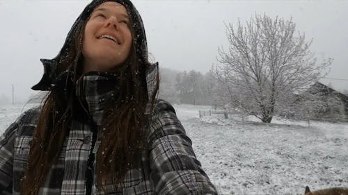 A Woman Walking In Circle Enjoys The Falling Snow