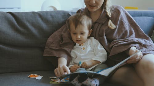 A Woman Showing Her Child An Educational Book 