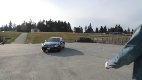 A Man Walking Towards A Parked Car