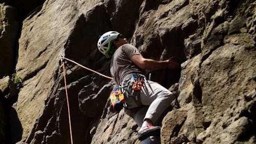 A Man Climbing The Mountain Rocks