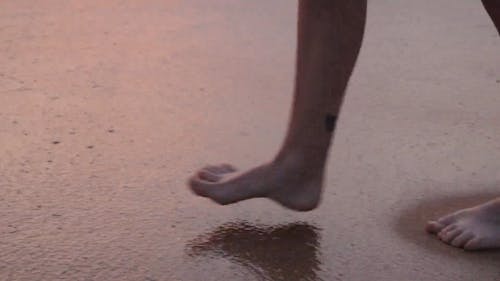 Close-up Shot of a Woman's Legs while Walking on the Beach