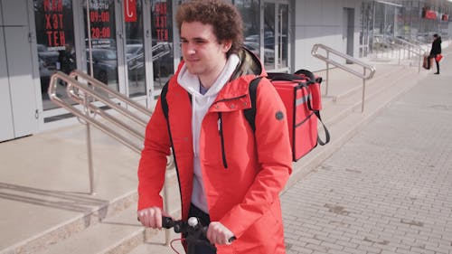 A Delivery Man Riding his Scooter