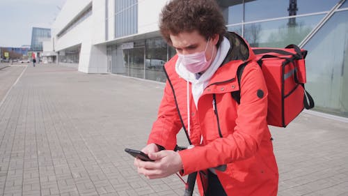 A Delivery Man Using His Cellphone 