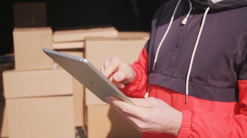 A Man Looking For The Coordinates To Deliver Boxes Of Goods