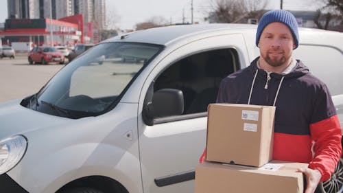 A Delivery Man Carrying Boxes Of Goods