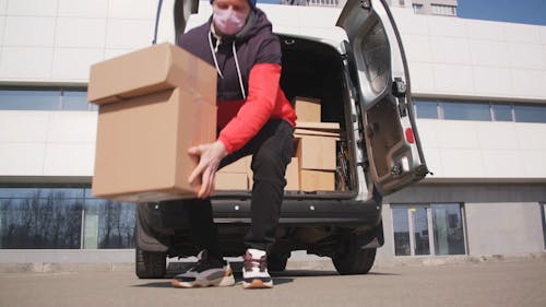 A Delivery Man Unloading Boxes from a Van