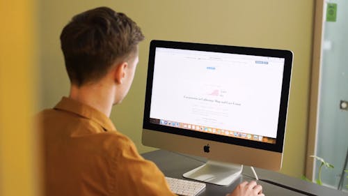 Man Searching for Information in the Internet Using an Imac