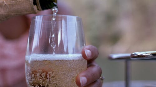 Pouring Champagne On A Glass