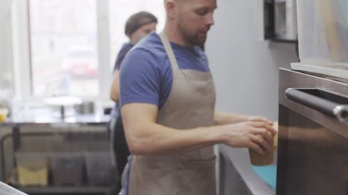 Man Putting Food And Drink In A Thermal Bag For Delivery