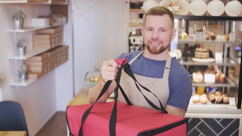 A Baker Setting Up Foods On A Thermal Bag For Delivery