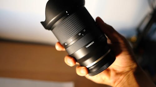 A Person Holding a Tamron Camera Lens