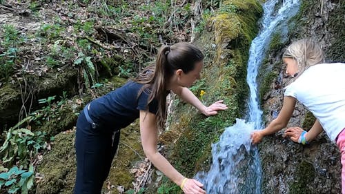 Woman Drinking From A Waterfalls