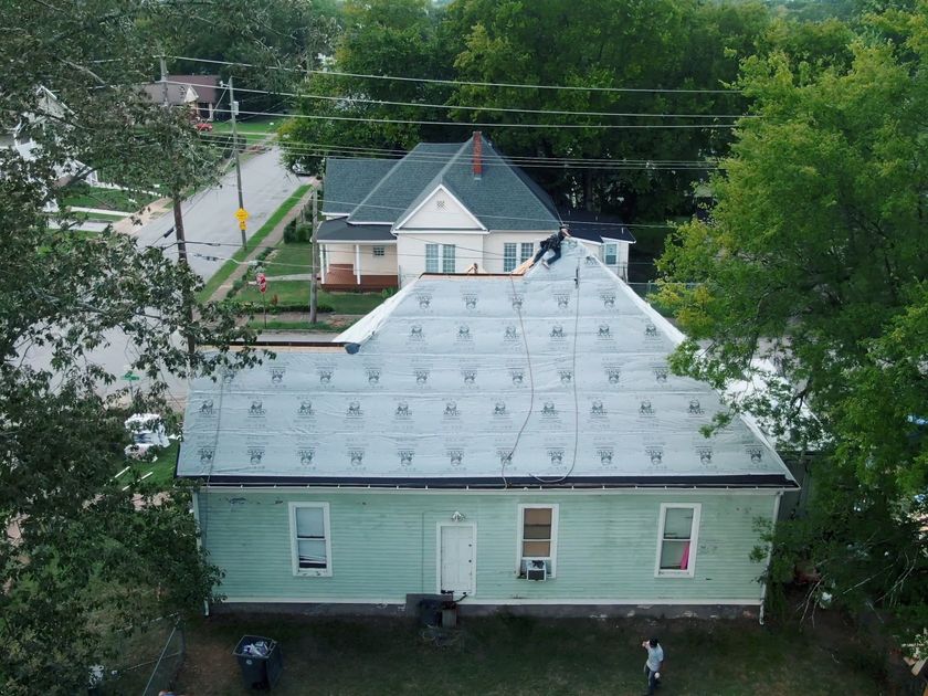 Close drone pass over a fresh shingled ridge line at midday