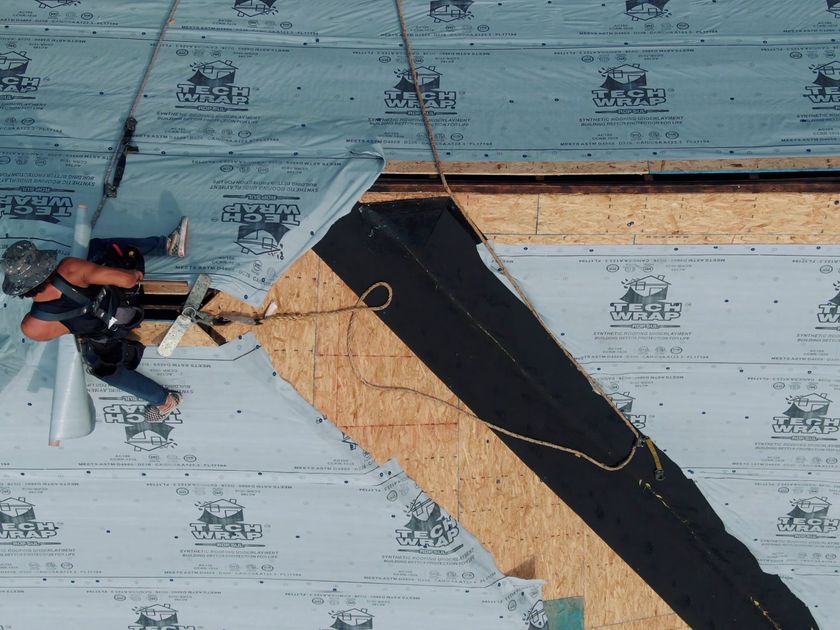 Drone pulling back from a completed composition roof on a two-storey home