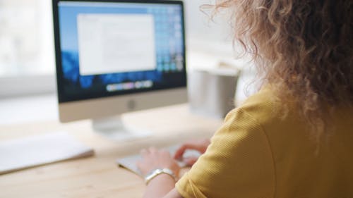 A Woman Typing on a Laptop