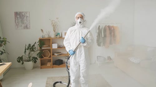 A Woman Is Wearing Protective Gears In Decontaminating Her Home 