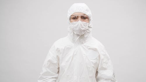 A Person in a Protective Suit Holding a Heart Logo