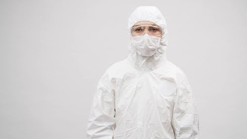 A Person in a Protective Suit Holding a House Logo