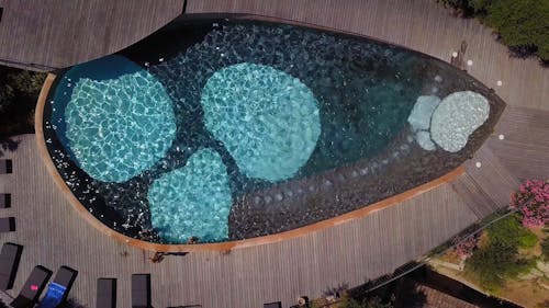 Drone Footage Of Kids Swimming In A Tear Shaped Pool