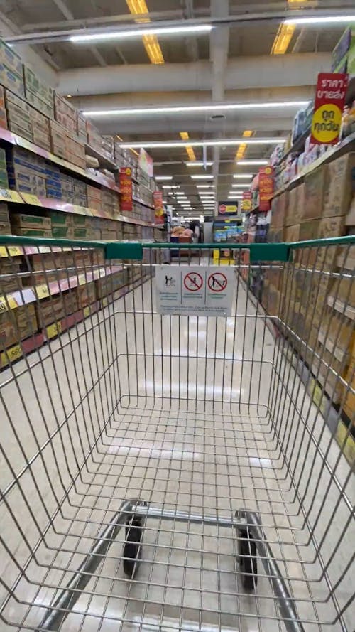 Filling A Shopping Cart With Groceries In A Supermarket