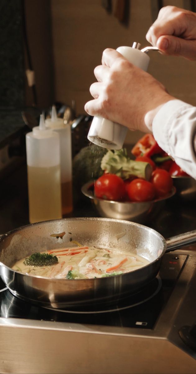 a chef is preparing food in a pan on a stove 4252336