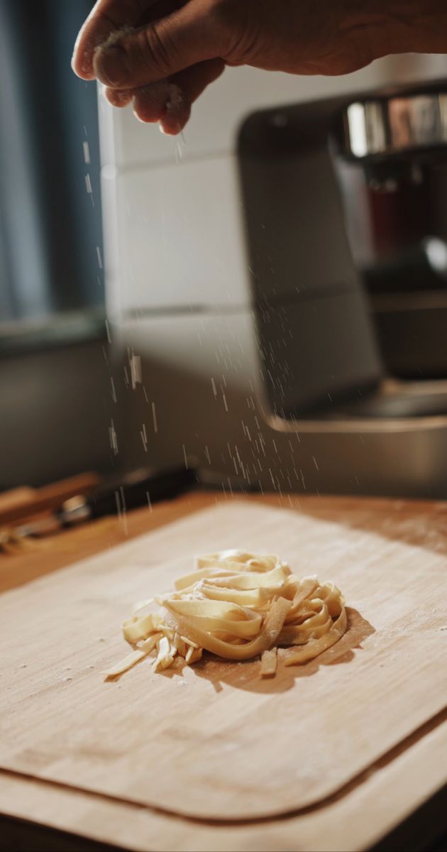 a person is cutting pasta on a cutting board 4252798