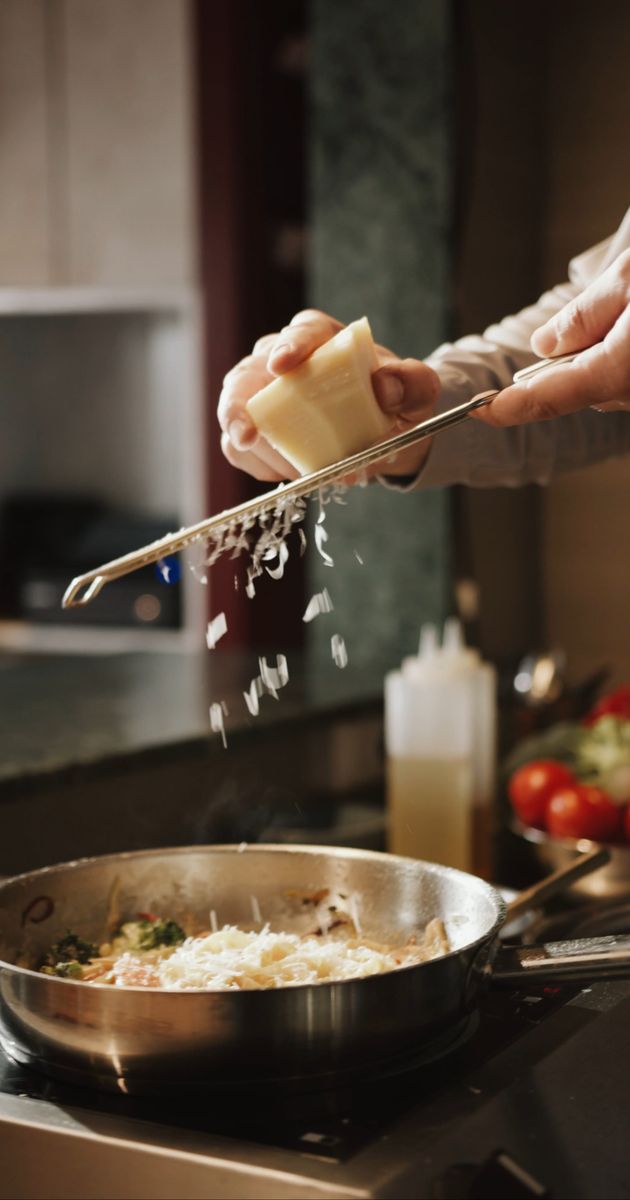 a woman stirring food in a pan on a stove 4253143
