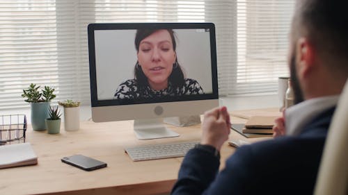 A Man Working At His Home Office Engaged In A Video Call