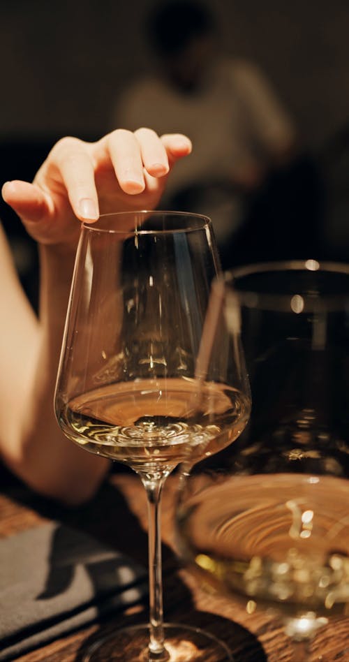 A Woman Running Her Fingers On A Wine Glass Rim