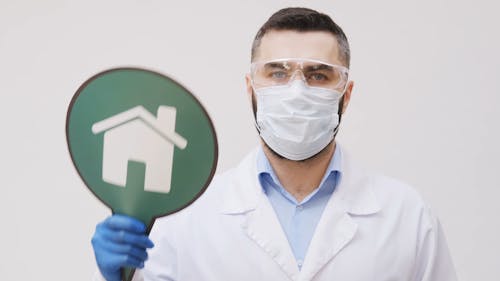 A Health Worker Holding A Stay At Home Signboard