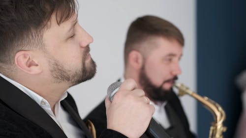 A Singer Singing Accompanied By A Saxophonist Music