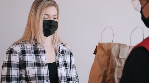 Woman With Face Mask Paying for a Delivery