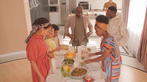 A Family Setting Up Food In The Dining Table