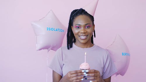 Woman With a Party Hat Holding a Cupcake