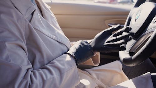 A Person in the Car Putting On a Latex Gloves