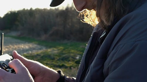 A Man Using a Drone Remote Controller