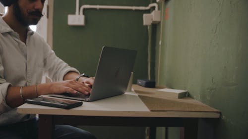 A Man Talking on the Phone after Using his Laptop