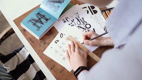 Man Writing The Alphabet In Different Fonts