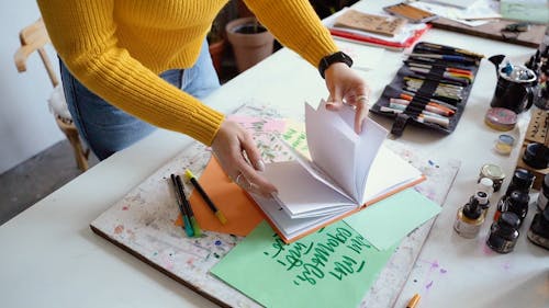 A Woman Flipping on Her Calligraphy Portfolio