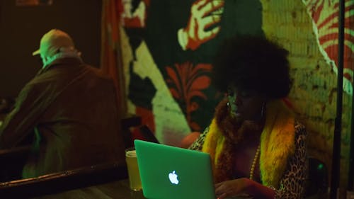Man and Women Using Laptop at the Club