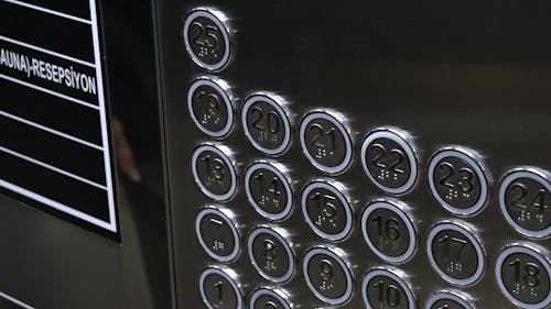 A Person Pressing an Elevator Button with a Tissue