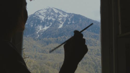 A Woman Doing A Painting Of The Mountain 