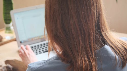 A Woman Typing on a Laptop