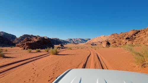 A Desert land With Vehicle Driving Under Blue Sky