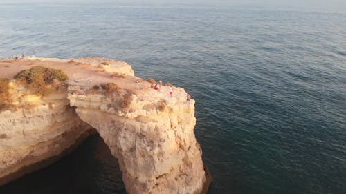 A Revolving Shot of People Stranding on a Coastal Cliff