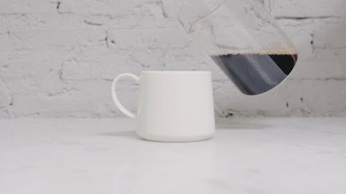 A Person Pouring Coffee on the Cup