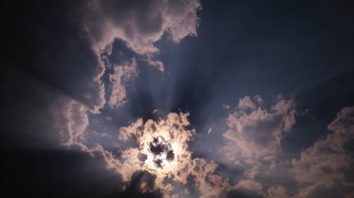 The Sun Hiding Behind The Clouds In The Sky