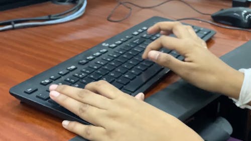 Close-Up Shot of a Person Typing on a Computer Keyboard