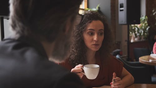 Woman Drinking Coffee During Meeting